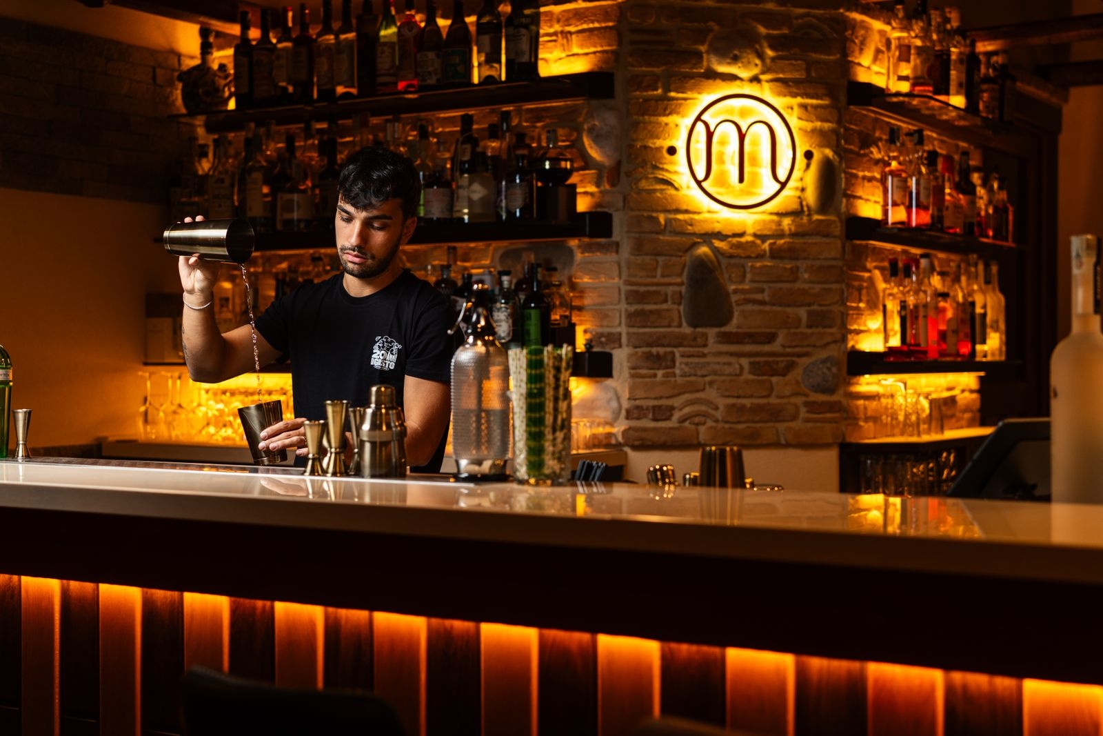 Bartender mixing cocktails at a stylish bar